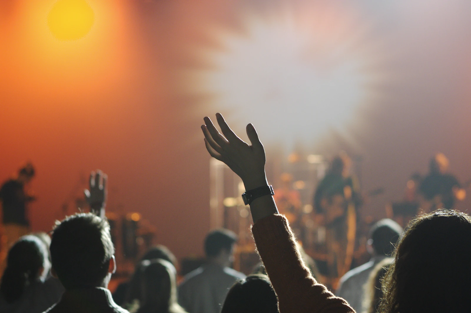 Congregation worshiping together under warm stage lights